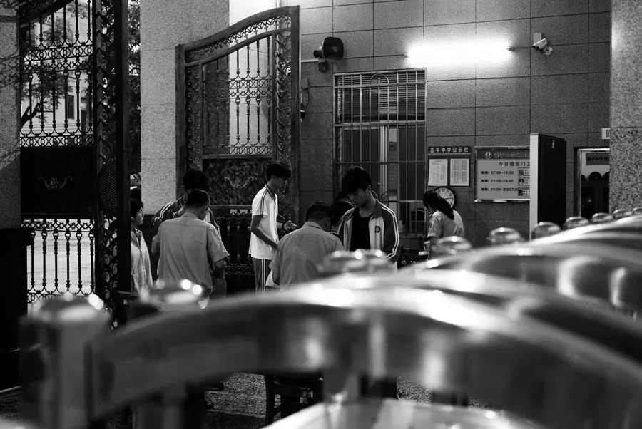 连平中学门口，学生聚在铁艺大门与门卫室附近