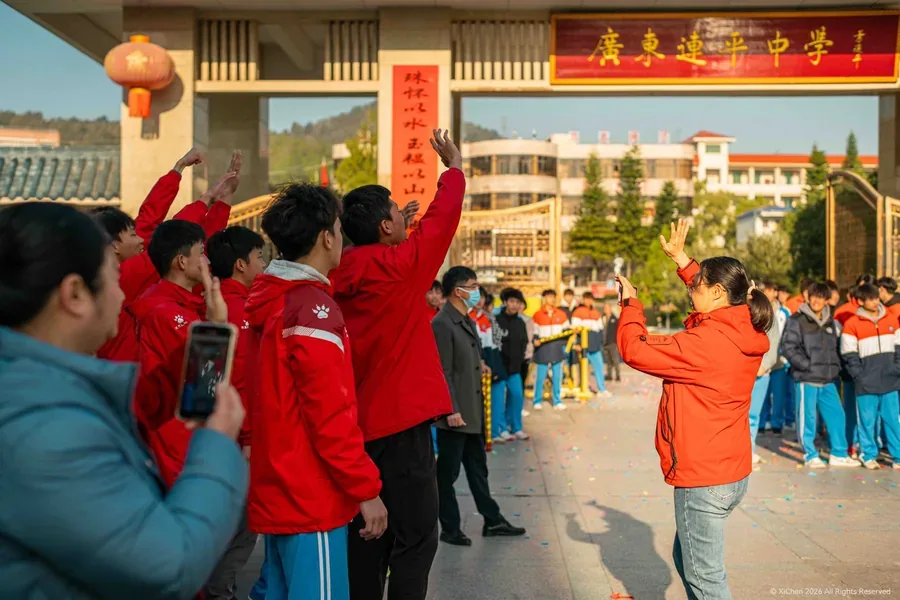 广东连平中学校门前，师生挥手，地面散落彩纸屑